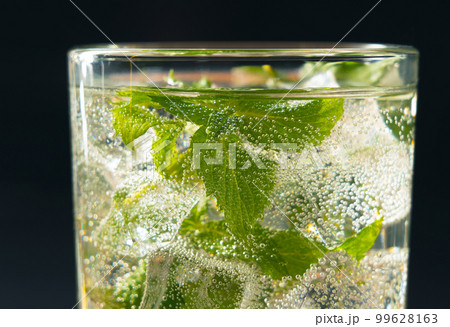 Mojito cocktail in a glass with ice cubes and mint close-up Mojito cocktail in a glass with ice cubes and mint close-up 99628163