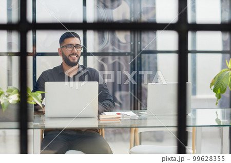 Middle-aged man working on laptop in office Middle-aged man working on laptop in office 99628355