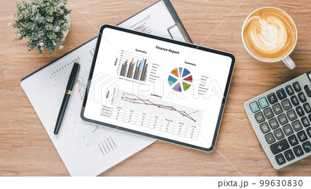 Tablet screen display with charts and reports on office desk workplace. Top view flat lay 99630830