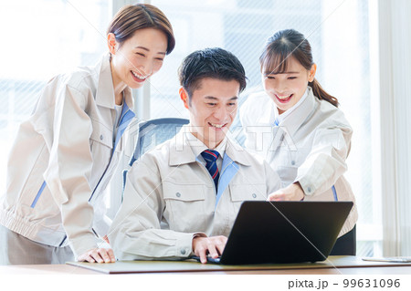 オフィスでパソコンを使う作業服を着た人々 99631096