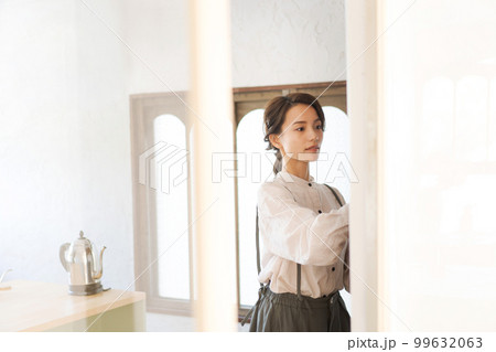 食器棚に食器をしまう女性 99632063