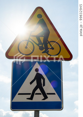 Round road sign depicting white bicycle on blue background, meaning mandatory bike path for cyclists against blue sky background. Blue round sign on bike path pole Round road sign depicting white bicycle on blue background, meaning mandatory bike path for cyclists against blue sky background. Blue round sign on bike path pole 99632945