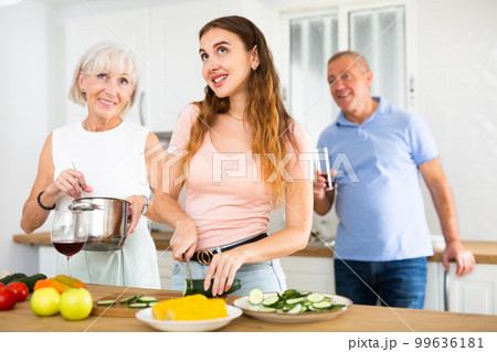 Happy family of three preparing lunch together in modern kitchen Happy family of three preparing lunch together in modern kitchen 99636181