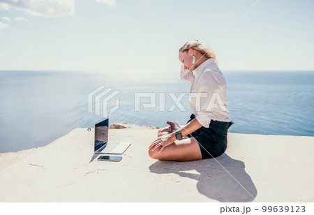 Woman sea laptop yoga. Business woman freelancer in yoga pose working over blue sea beach at laptop and meditates. Girl relieves stress from work. Freelance, digital nomad, travel and holidays concept Woman sea laptop yoga. Business woman freelancer in yoga pose working over blue sea beach at laptop and meditates. Girl relieves stress from work. Freelance, digital nomad, travel and holidays concept 99639123