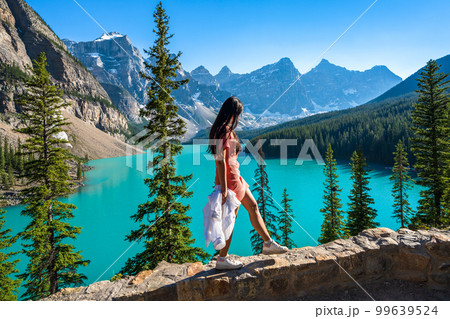 Young girl enjoying Moraine Lake beautiful scenery. Banff National Park nature landscape. Canadian Rockies summer time. Alberta, Canada. 99639524