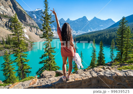Young girl enjoying Moraine Lake beautiful scenery. Banff National Park nature landscape. Canadian Rockies summer time. Alberta, Canada. 99639525