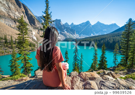 Young girl enjoying Moraine Lake beautiful scenery. Banff National Park nature landscape. Canadian Rockies summer time. Alberta, Canada. 99639526