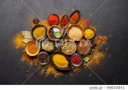 Various spices in bowls and spoons on stone table Various spices in bowls and spoons on stone table 99639841