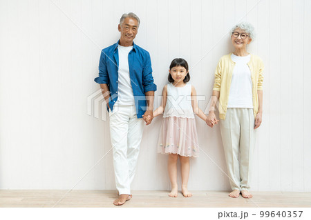 手をつなぐシニア夫婦と孫の女の子 手をつなぐシニア夫婦と孫の女の子 99640357