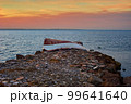 Old abandoned damaged fishing boat laying on the stone pier 99641640