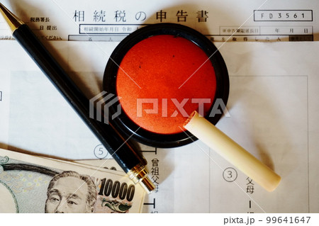 等親図と相続税申告書の上に置かれた印鑑とペン、一万円札 99641647