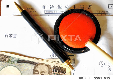 等親図と相続税申告書の上に置かれた印鑑とペン、一万円札 99641649