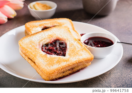 Heart shaped toast with raspberry jam on a plate. Food for lovers. Heart shaped toast with raspberry jam on a plate. Food for lovers. 99641758
