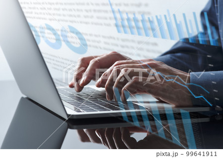 ビジネスの報告書。ノートパソコンで書類を作る男性。タイピングをする手のアップ。 99641911