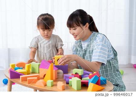 ブロックで遊ぶ児童と保育士 99646017