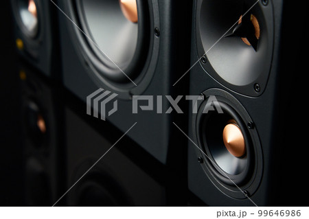 Two sound speakers and subwoofer on dark background. Set for listening music. Audio equipment 99646986