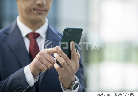 スマートフォンを操作するビジネスマンの手元 撮影協力「LINK FOREST」 スマートフォンを操作するビジネスマンの手元 撮影協力「LINK FOREST」 99647790
