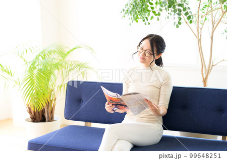 パンフレットを見ながら検討中の眼鏡の女性 99648251