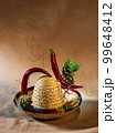 abstract composition assembled from a Mexican hat, hot pepper, wire and cacti 99648412