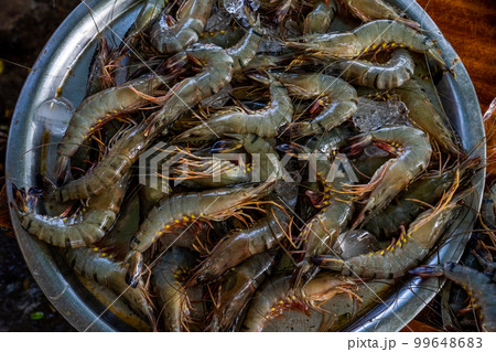Raw whole shrimps for sale in a Fish market. Seafood Market with fresh caught prawns for sale. Heap of prawns on seafood market. Tropical marine crustaceans 99648683
