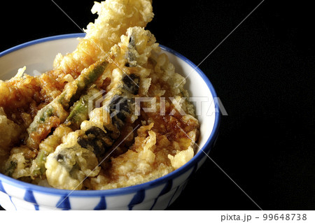 穴子と茄子、南瓜やインゲンの天ぷらが乗っている天丼を黒背景で撮影 99648738