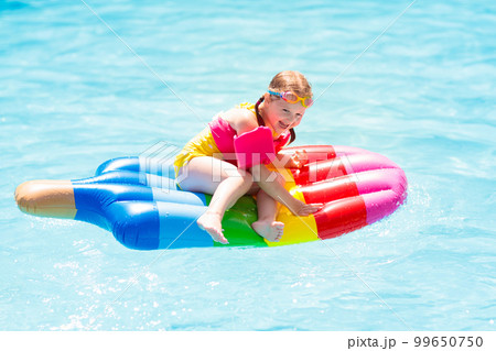 Child on inflatable float in swimming pool. Child on inflatable float in swimming pool. 99650750