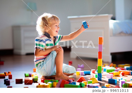 Child playing with colorful toy blocks. Kids play. 99651013