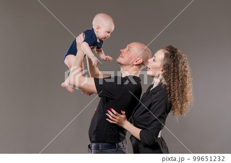 Young family photographed with small child. Father holds child in his arms Young family photographed with small child. Father holds child in his arms 99651232