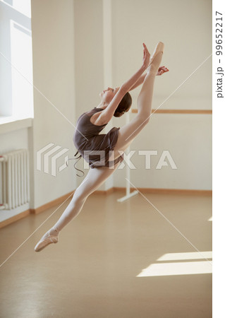 Tender graceful ballerina, teen girl training, dancing on pointe shoes. Model at ballet school on daytime with sunlight. Concept of classical ballet, art, choreography 99652217