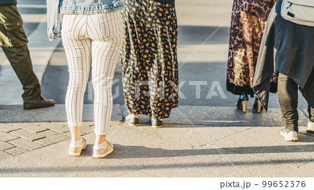 Abstract background of people standing on crosswalk, getting ready to cross road at city street 99652376