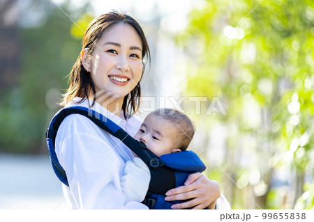 抱っこ紐で育児をする若い女性 99655838