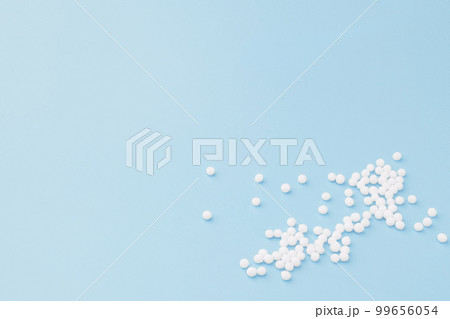 Homeopathic globules scattered on a blue background. Alternative Homeopathy medicine. Homeopathic globules scattered on a blue background. Alternative Homeopathy medicine. 99656054