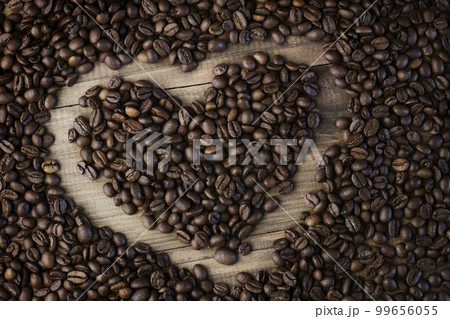 Coffee beans background. Organic coffee. Coffee beans on a wooden background in the form of a heart Coffee beans background. Organic coffee. Coffee beans on a wooden background in the form of a heart 99656055