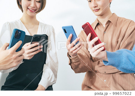 スマホを見せ合う若いグループ 99657022