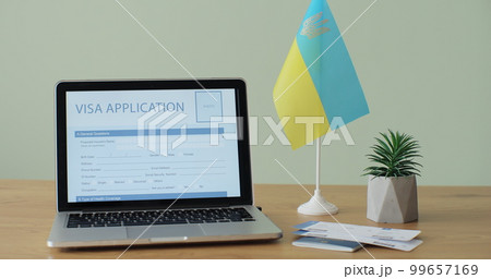 Online Ukranian Visa Application showing on a laptop computer screen sitting on a desk. Travelling abroad or immigration concept. 99657169