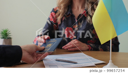 Ukranian embassy woman officer giving passport to man immigrant, student visa approval, work visa, citizenship. Visa Application online form immigration concept. Visa approval. Ukranian embassy woman officer giving passport to man immigrant, student visa approval, work visa, citizenship. Visa Application online form immigration concept. Visa approval. 99657254
