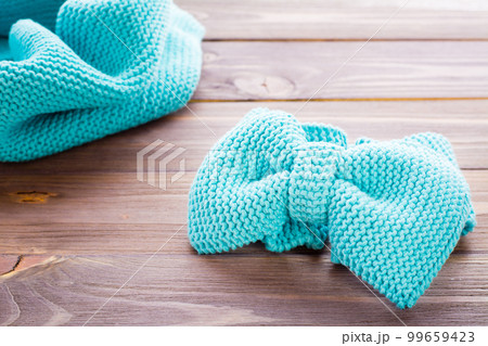 Knitted mint headband  and snud on a wooden table 99659423