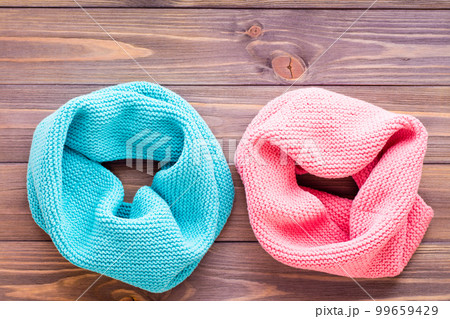 Mint snud and pink snud on a wooden background. Top view 99659429