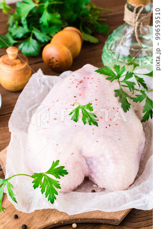 Raw chicken breast on a frame in spices and herbs on a cutting board on a wooden table Raw chicken breast on a frame in spices and herbs on a cutting board on a wooden table 99659510