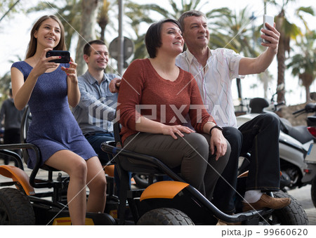 family of tourists enjoy a walk on the bike carriage family of tourists enjoy a walk on the bike carriage 99660620
