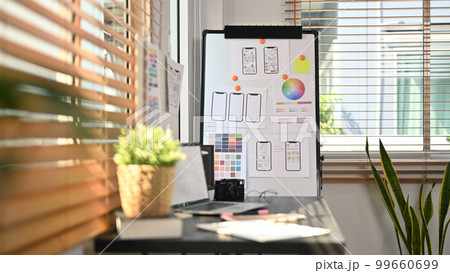 Creative office with laptop, stationery and wireframe sketches of screens for mobile application on a flip board 99660699