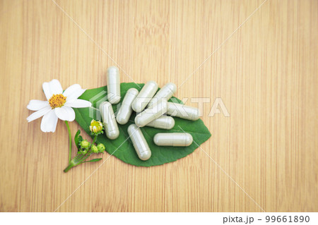 Herbal medicine in capsules from herb leaf on rustic wooden table with copy space for medical background. healthy eating with natural product for good living. Herbal medicine in capsules from herb leaf on rustic wooden table with copy space for medical background. healthy eating with natural product for good living. 99661890