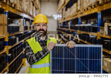 Portrait of warehouse worker with solar panel. 99662735