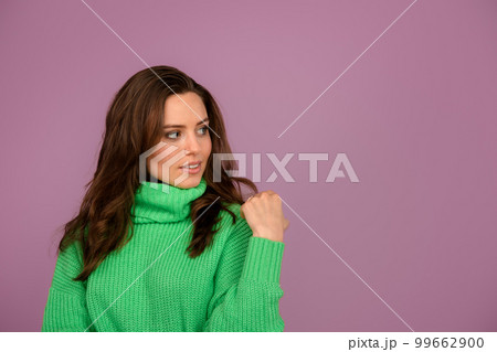 Young woman posing in sweater during studio shooting. Young woman posing in sweater during studio shooting. 99662900