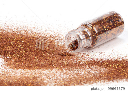 Gold sparkles pour out of the bottle. Glitter is pouring from a bottle on a white background Gold sparkles pour out of the bottle. Glitter is pouring from a bottle on a white background 99663879