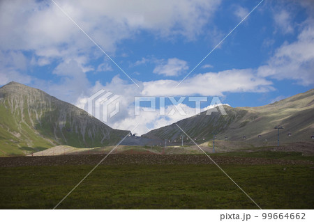 Summer mountain landscape and a cable car in the distance. Summer mountain landscape and a cable car in the distance. 99664662