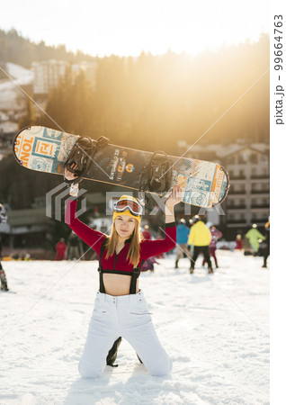 A beautiful girl snowboarder sits on a slope, resting after a difficult descent A beautiful girl snowboarder sits on a slope, resting after a difficult descent 99664763