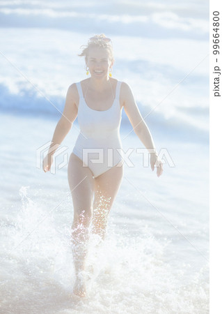 smiling woman in beachwear at beach having fun time smiling woman in beachwear at beach having fun time 99664800