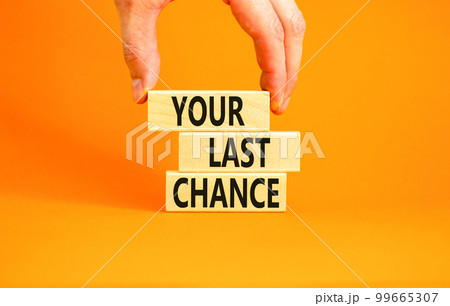 Time to your last chance symbol. Concept words Your last chance on wooden blocks on a beautiful orange table orange background. Businessman hand. Business and your last chance concept. Copy space. 99665307