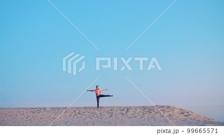 Healthy, young beautiful woman meditating, stretching, practicing yoga on the sea beach, at sunrise, Makes exercises for balance and coordination, deep muscle tone. Healthy, young beautiful woman meditating, stretching, practicing yoga on the sea beach, at sunrise, Makes exercises for balance and coordination, deep muscle tone. 99665571
